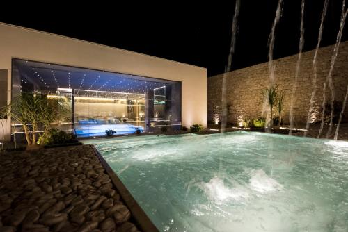 a swimming pool at night with a building at Pietre Nere Resort & Spa in Modica