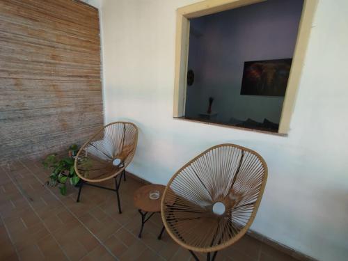 deux chaises et un miroir dans une pièce dans l'établissement Sunset Flats - Bonito Flat na Rua Pituba 1 , bem perto das praias urbanas! Itacare BA 2, à Itacaré