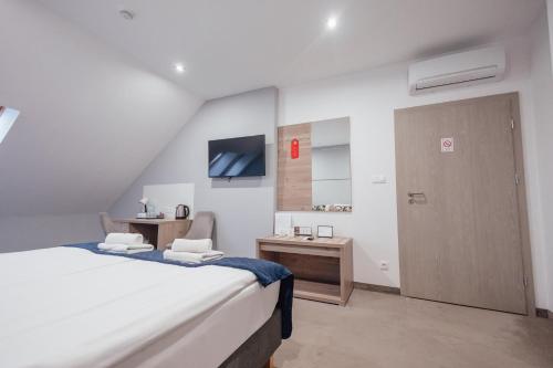 Schlafzimmer mit einem Bett, einem Schreibtisch und einer Tür in der Unterkunft Hotel Garbów *** Centrum Konferencyjno - Bankietowe in Garbów