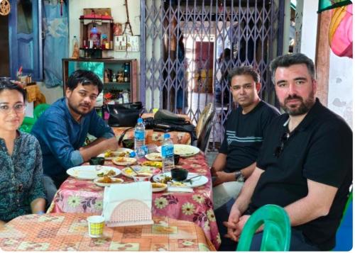 Un groupe d'hommes assis autour d'une table avec de la nourriture dans l'établissement AALTAPORI HOMESTAY- BEST HOMESTAY in BUXA-JAYANTI, à Jayanti
