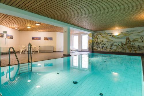 a swimming pool with a painting on the wall at Haus Weesterhuk, Whg 8 Jopi Keitum in Keitum