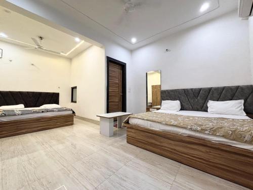 une chambre avec deux lits et une table dans l'établissement Hotel Devi Heritage - Near Prem Mandir, à Vrindavan