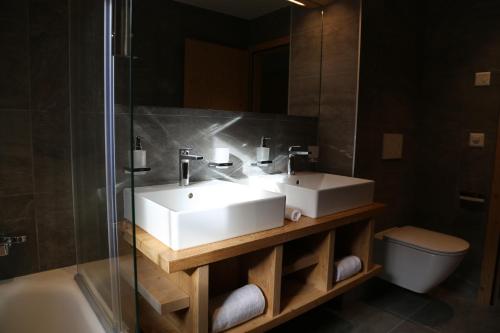 une salle de bain avec un lavabo, une douche et des toilettes dans l'établissement Dent Blanche Resort - TemptingPlaces Collection, à Hérémence