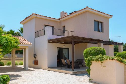 a house with a balcony and a table and chairs at Seaview Villa Mia in Lachi