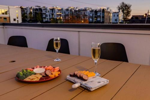 a table with a plate of food and two glasses of wine at Luxury Condo - The Gulch - Private Rooftop in Nashville