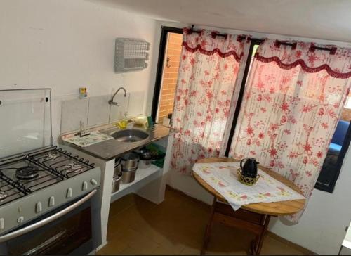 eine kleine Küche mit Herd und Spüle in der Unterkunft Lar do Litoral - Praia Grande in Praia Grande