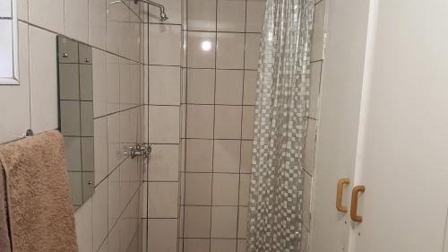 a shower with a glass shower curtain in a bathroom at Ras Vill in Glencairn