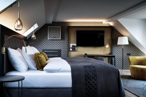a hotel room with a bed and a tv at Sorell Boutique-Hotel Seefeld Zürich in Zurich