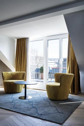 a living room with two chairs and a table at Sorell Boutique-Hotel Seefeld Zürich in Zurich
