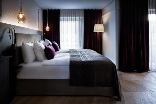 a bedroom with a large bed with pillows at Sorell Boutique-Hotel Seefeld Zürich in Zürich