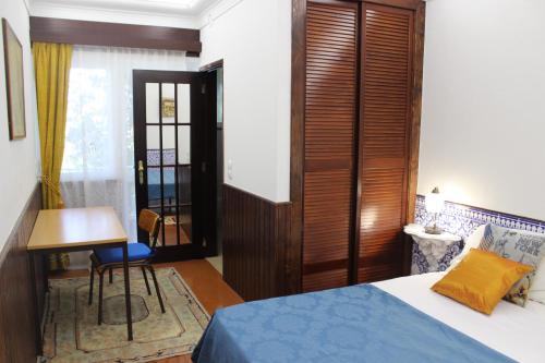 a bedroom with a bed and a desk and a table at Cascais Jasmim Doce in Cascais