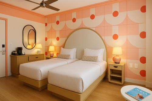 a bedroom with two beds and a mirror at Waldorf Towers South Beach in Miami Beach