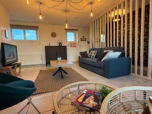 a living room with a couch and a table at Trois pièces vue campagne à Bâlines in Balines