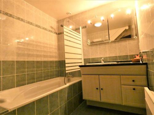 a bathroom with a tub and a sink and a bath tubermottermott at Notre bergerie in Soustons