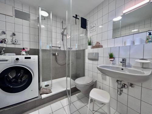 ein Badezimmer mit Waschmaschine und Waschbecken in der Unterkunft Ferienwohnung Karma in Kressbronn am Bodensee