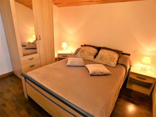 a bedroom with a large bed with two night stands at L'ecureuil in Soustons