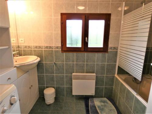 a bathroom with a sink and a toilet and a window at L'ecureuil in Soustons