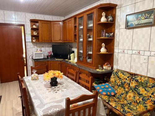 a kitchen with a table and a couch and a table and a table andheastern at Omma's Haus - Casa de Vó perto de Gramado in Morro Reuter