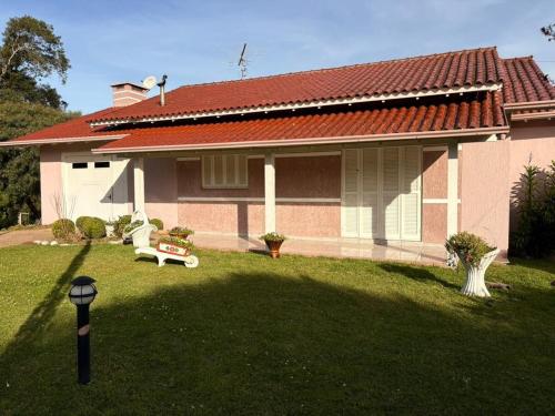 ein Haus mit einer Bank vor einem Hof in der Unterkunft Omma's Haus - Casa de Vó perto de Gramado in Morro Reuter