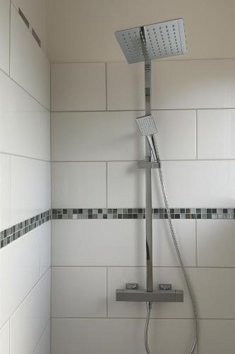 a shower with a light in a white bathroom at Villa Valey, spacious and authentic in Le Lamentin