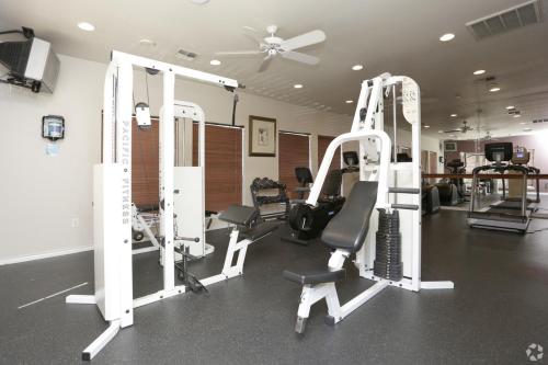 a gym with several tread machines and a fan at The Reside Fully Furnished Condos - Medical Stays Welcome in Houston