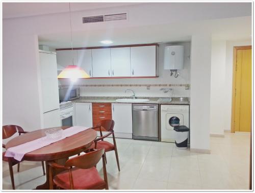 a kitchen with a wooden table and a table and chairs at Acogedor apartamento en el Casco Historico in Jávea