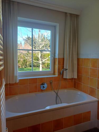 eine Badewanne im Bad mit Fenster in der Unterkunft Privatzimmervermietung Wiederkehr in Altenmarkt im Pongau