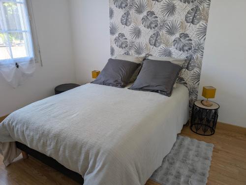 a bedroom with a white bed with two pillows at Logis Coeur de Bretagne in Bieuzy-les Eaux