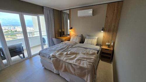 a hotel room with a bed and a large window at Beachfront Premium Apartment with Sunset, Pools & Sea View in Portimão