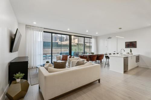 a living room with a white couch and a kitchen at The Theodore New Orleans in New Orleans