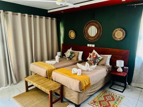 two beds in a bedroom with green walls at Rustic Gate Lodge and Campsite in Maun