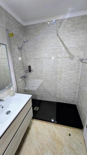 a bathroom with a shower with a sink and a toilet at Beachfront Premium Apartment with Sunset, Pools & Sea View in Portimão