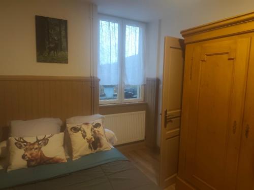 a bedroom with a bed with paintings of cows on the pillows at Les Locations de Stéphanie ,gîte L'Arbre Vert in Sondernach