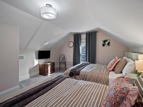 a attic bedroom with two beds and a tv at Cleveland Escape - Hot Tub - Karaoke Machine - Sleeps 12 in Cleveland