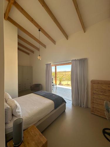 a bedroom with a bed and a large window at Idyllic Farm in Springbok