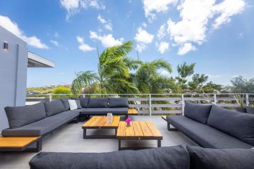 a living room with blue couches and a table at Casa di Mama Villa with Private Pool in Jan Thiel