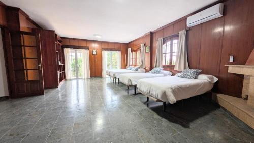 three beds in a room with wooden walls at Villa Mona Private pool and barbecue in Malaga in Málaga