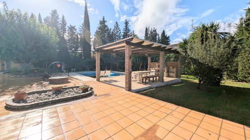 a patio with a gazebo and a pool at Villa Mona Private pool and barbecue in Malaga in Málaga