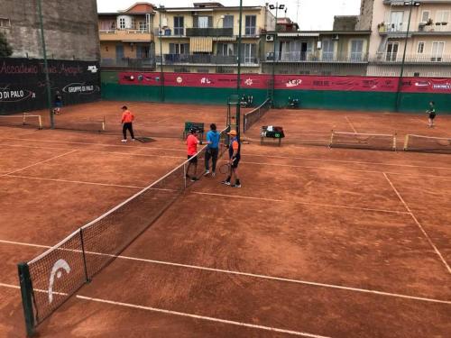 a group of people standing on a tennis court at Habibi Gerard in Torre del Greco