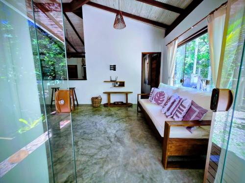ein Wohnzimmer mit Couch und Glasdusche in der Unterkunft Casa Recanto ViVaMar - 3 bedroom house, 10 min from the beach in Barra Grande