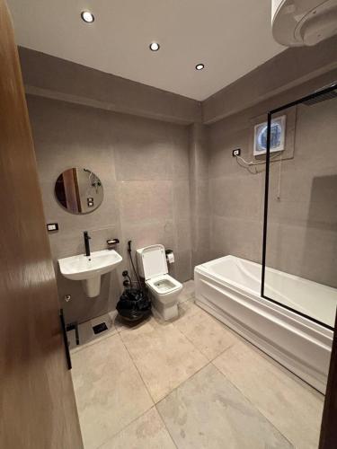 a bathroom with a toilet and a tub and a sink at Wazidi Resort in Siwa