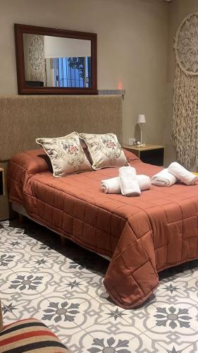 a bedroom with a large bed with towels on it at La Luján Ayres de Campo in Luján