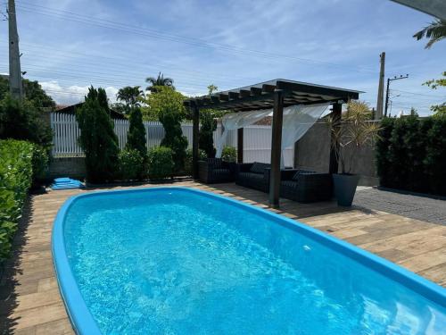 ein Swimmingpool in einem Hof mit einem Pavillon in der Unterkunft Refúgio Rustico em Penha in Penha