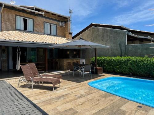 ein Hinterhof mit einem Swimmingpool und einem Haus in der Unterkunft Refúgio Rustico em Penha in Penha