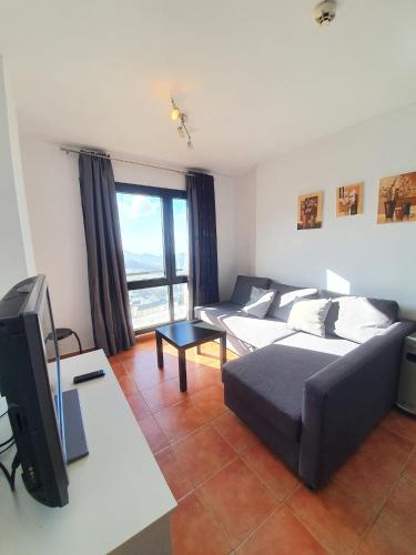 Una sala de estar con un sofá y un televisor. en Monte Oiz junto a telesilla ERB Alojamientos, en Sierra Nevada