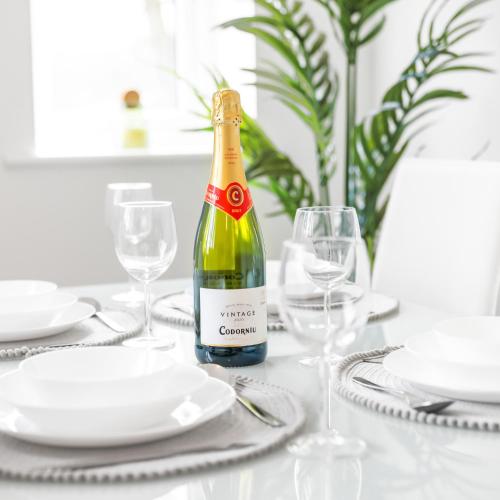 a bottle of wine sitting on a table with glasses at Modern Two Bed Apartment - Smart Tv - Wi-Fi - Parking 49C in Sleightholme