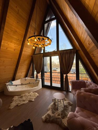 um quarto amplo com uma banheira e um lustre em Beaver lodge - Dabrova Koliba em Bijeljina