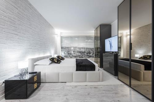 a bedroom with a white bed and a tv at Gramsci Prestige Apartment in Bologna