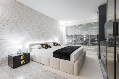 a bedroom with a large bed and a brick wall at Gramsci Prestige Apartment in Bologna