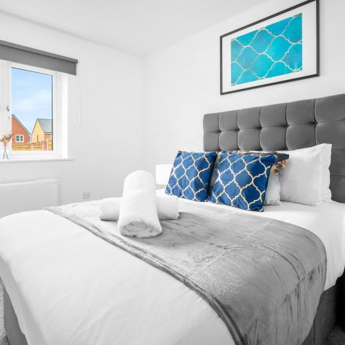 a bedroom with a large white bed with blue pillows at Modern Two Bed Apartment - Smart Tv - Wi-Fi - Parking 49C in Sleightholme